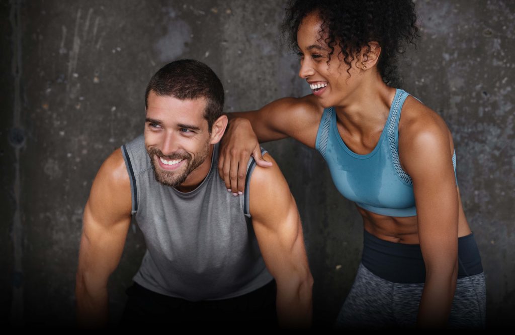 Uomo e donna sorridono dopo un allenamento insieme