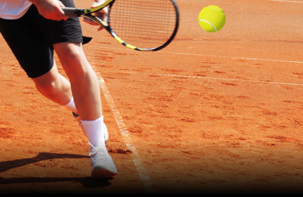 Persona in campo da tennis sta per colpire la pallina con la racchetta